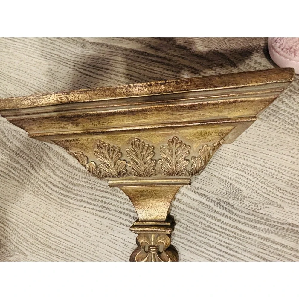 Vintage gold-toned decorative wall shelves with floral motifs.